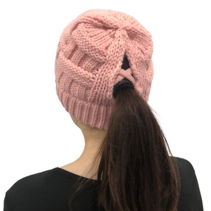 Detail view of the pink knitted ponytail beanie with a unique cross-open back design