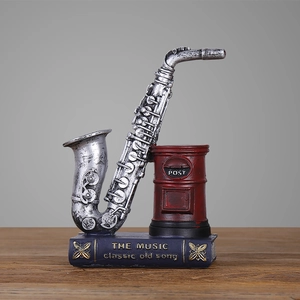 Vintage saxophone and red postbox resin desk organizer on a music book base