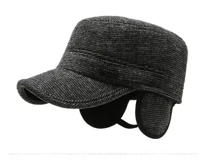 Detail of dark grey winter flat cap with ear flaps and SPORT metal label on side