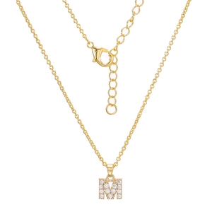 Macro shot of gold letter M pendant with sparkling zircon inlays on a dainty chain