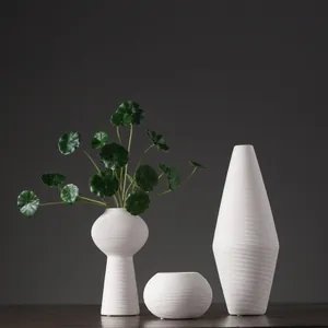 Minimalistische witte keramische vazenset met horizontale geborstelde textuur