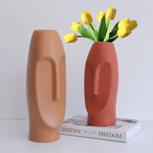 Minimalist Morandi ceramic face vases in matte brown and brick red with yellow tulips