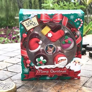 Detailed view of a 5-piece cartoon Christmas eraser set in a festive green gift box