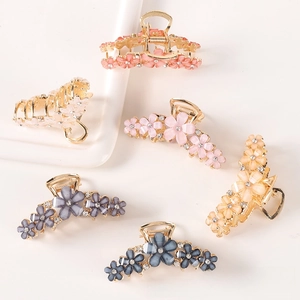 Detail of crystal flower hair claws with cat-eye petals and gold-plated alloy base