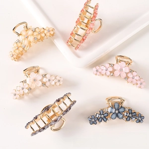 Detailed close-up of crystal flower hair claws with colorful petals and gold alloy finish