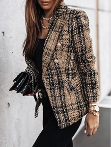 Detail of double-breasted tweed blazer with metallic buttons and classic plaid pattern