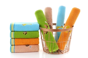 Detail of soft cotton kids towels with cartoon animal embroidery in a gold wire basket