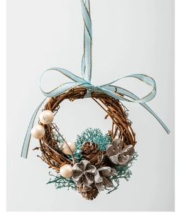 Close-up of mini Christmas wreath with pine cones and light blue ribbon on grey background