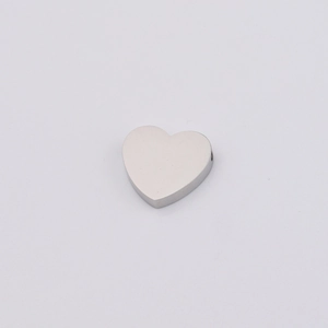 Macro detail of a polished heart-shaped stainless steel bead for DIY jewelry making