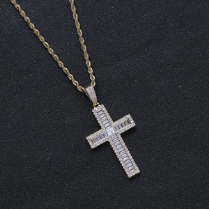 Macro view of gold-plated cross pendant with cubic zirconia on twisted chain