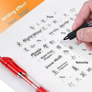 Close-up of hand writing with 0.5mm retractable gel pen in black and red ink