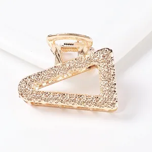 Macro shot of a golden triangle claw clip with sparkling glitter texture detail
