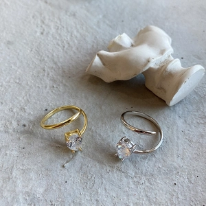 Macro view of gold and silver spiral rings with sparkling four-prong solitaire crystals