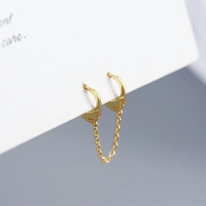 Detailed view of gold S925 sterling silver cuff link earrings with chain design