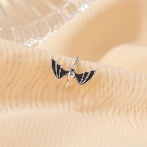 Gothic silver bat ear cuff with black wings on soft fabric, Halloween jewelry