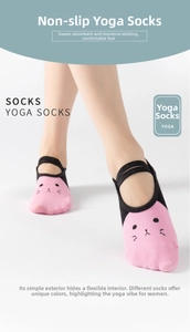Detail of pink and black yoga socks with cat face pattern and non-slip cross straps