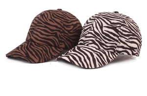Detail view of zebra print baseball caps in brown and classic black-and-white cotton