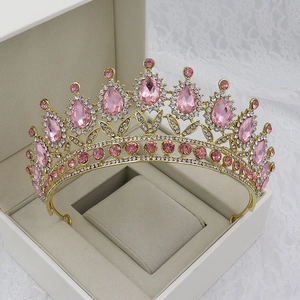 Detail of a golden Baroque bridal crown with pink teardrop crystals in a jewelry box