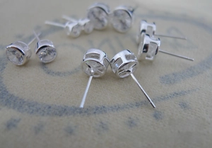 Macro shot of 925 sterling silver stud earrings featuring round bezel-set clear zircon
