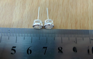 Macro view of 6mm clear cubic zirconia stud earrings in S925 sterling silver with a ruler