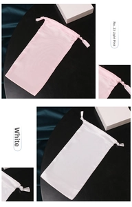 Detail showing satin drawstring gift bags in light pink and white smooth silk texture