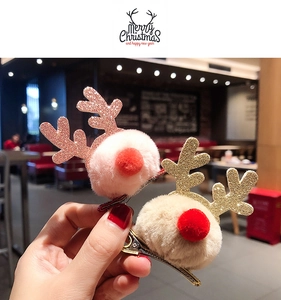 Detail of glitter reindeer antlers hair clip with plush pom poms and metal base