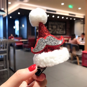 Close-up of a festive red glitter Santa hat hair clip with plush trim and silver beard detail