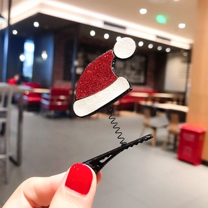Close-up of a red glitter mini Santa hat hair clip with white fur and black spring detail