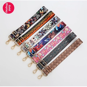 Detail of adjustable bag straps with ethnic patterns and golden metal hardware hooks