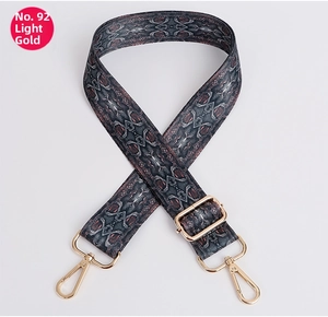 Detail of adjustable geometric strap with polished light gold metal hooks for handbags