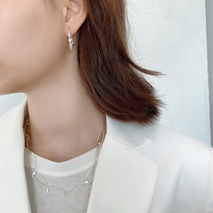 Close-up of 925 sterling silver woven earrings and chunky chain necklace on a model