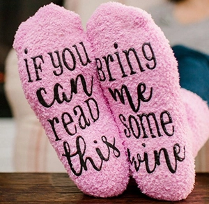 Macro shot of pink fuzzy socks featuring black printed text on the soles