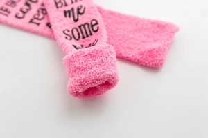 Detailed shot of pink coral fleece socks with If You Can Read This Bring Me Some Wine text