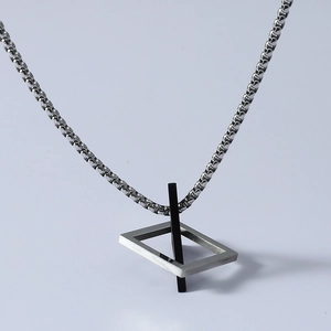 Detail of silver geometric cuboid pendant and black element on a steel chain necklace