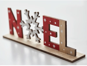 Close-up of wooden NOEL Christmas desktop ornament with snowflake and natural wood finish