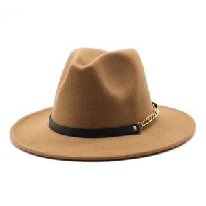 Detail of camel wool fedora hat featuring a black leather band and gold chain accent