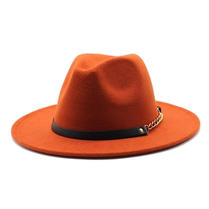 Detail of orange wool fedora featuring a black leather band and gold metal chain link