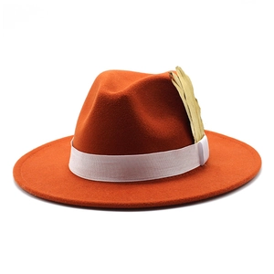 Close-up of orange wool fedora hat with white elastic band and golden feather detail
