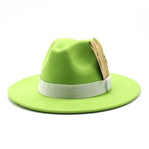 Detail of bright green wide brim fedora hat with white ribbon and golden feather pin