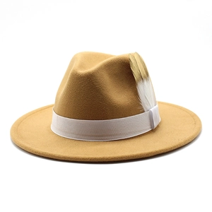 Détail du chapeau fedora en laine camel avec ruban satiné blanc et plume décorative élégante