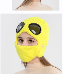 Detail of yellow knit aviator hat with goggles and buttoned face mask texture