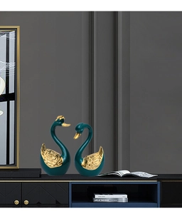 Close-up of golden swan neck details on dark green ceramic elegant home decor figurines