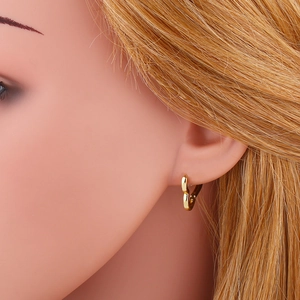 Elegant gold heart-shaped hoop earrings on female model for a minimalist jewelry look