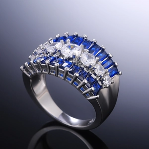 Macro detail of wide silver ring with blue rectangular stones and white round zircon pavé