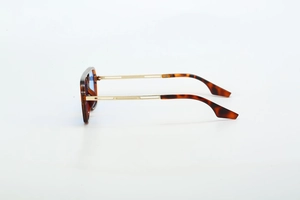 Detail of tortoiseshell frame aviator sunglasses with hollow gold metal temples and blue lenses