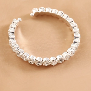 Sparkling silver stretch bracelet with clear crystals on luxury beige silk background