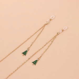 Golden eyewear chain with green enamel Christmas tree charms on a pink background