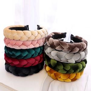 Macro shot of colorful braided velvet headbands in various rich shades on white surface