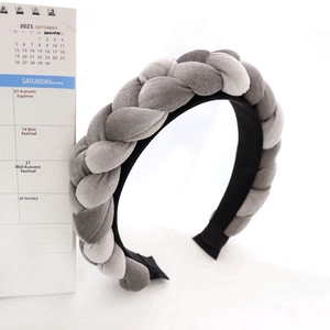 Detail view of a thick braided velvet headband in grey two-tone vintage twist design