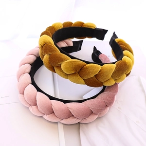 Detailed texture of braided velvet headbands in pink and yellow on a white shirt